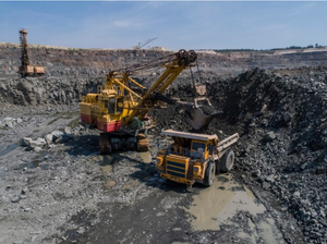 Huge-industrial-dump-truck-loaded-by-a-excavator-in-a-stone-quarry-loaded-transporting-marble